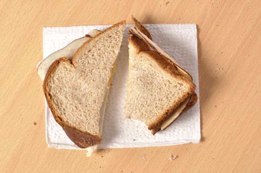 Closeup of plain lunchmeat sandwich on wheat bread on a napkin