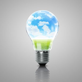 Electric light bulb and blue sky with clouds inside it