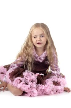 Winking little girl sitting on the floor