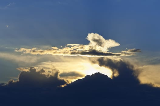 Dramatic sunburst through cumulus clouds in the evening