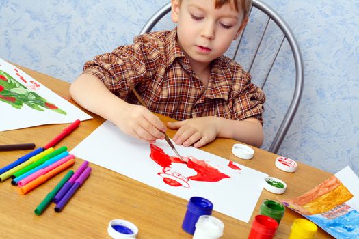 boy paints a Christmas picture