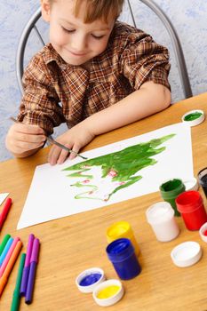 boy paints a Christmas picture