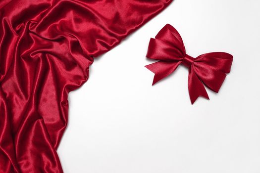 Shiny red satin ribbon on white background