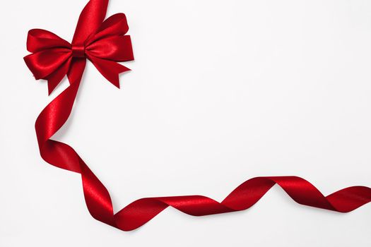 Shiny red satin ribbon on white background