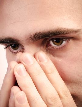 Close up of a man crying and a tear is running down a cheek