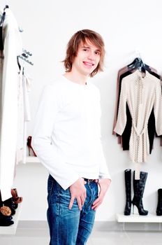 man in shop of clothes, smiles and is happy with purchases