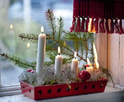 Burning candles in advent candle wreath setting fire on a curtain