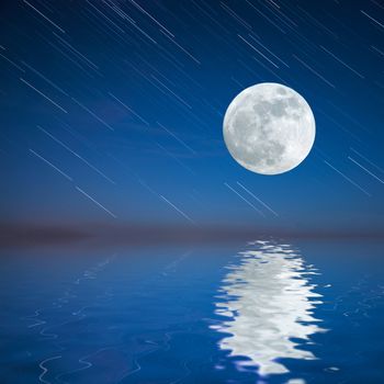 Night landscape with moon reflection in water and sky background with startrails