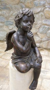 Cupid statue sitting made from black marble stone