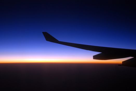 view from the airplane window at sunrise, with airplane wing 