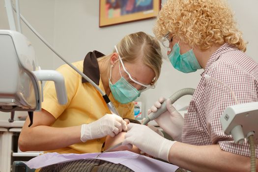 dental treatment. dentist and assistant treating the boy's teeth