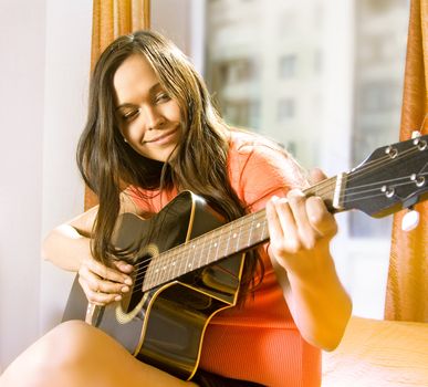 beautiful young lady in a room with guitar