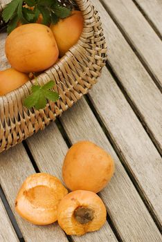 Fresh apricots in basket over wooden table