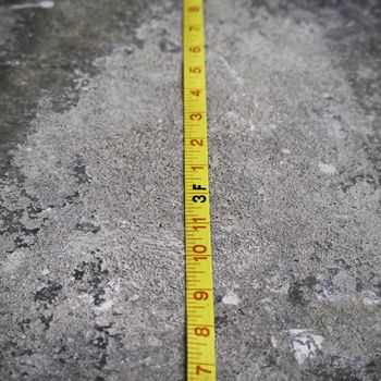 Construction Measuring Tape on Concrete Background 