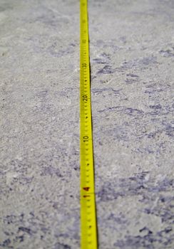 Construction Measuring Tape on grunge concrete floor