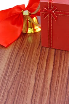 Gift box and red ribbon over wooden background 