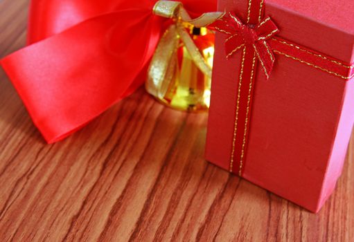 Gift box and red ribbon over wooden background 