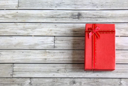 Red present box on wooden background 