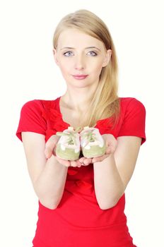 Woman holding baby shoes showing she is pregnant