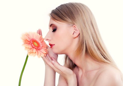 Woman on white background smelling pink flower