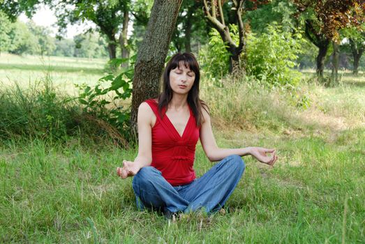 caucasian brunette woman in meditation pose outdoors