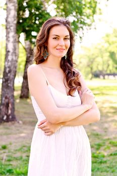 Portrait of an attractive woman in the park, crossed her arms