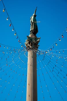 Public statue in Montevideo with blue sky and Christmas lights