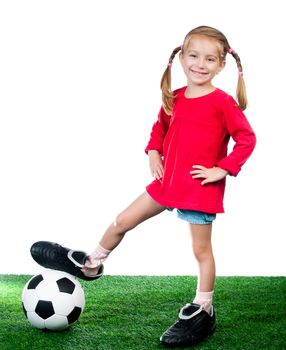 little girl with soccer ball in boots on a green lawn over white