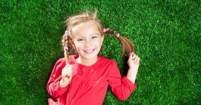 little girl smiling on a green lawn