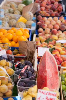 Arrangement of ripe fresh raw fruits in wooden boxes, plastic baskets at open street farmer’s market