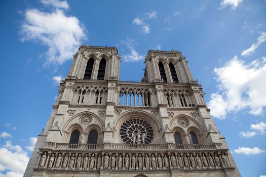 Famous landmark Gothic catholic cathedral Notre-dame on Cite island in Paris France on the blue and cloudy sky background