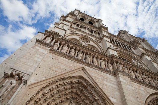 Famous landmark Gothic catholic cathedral Notre-dame on Cite island in Paris France on the blue and cloudy sky background