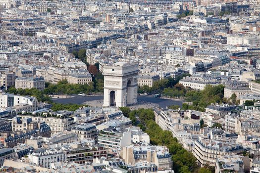 Top view on Triumphal Arch and Etoile square, roofs, housetops, city residential quarters and downtown, center streets in Paris France