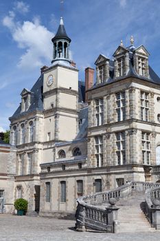 Medieval landmark royal hunting castle Fontainbleau near Paris in France on the cloudy sky background