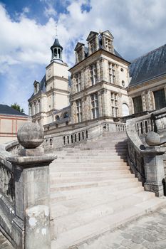 Medieval landmark royal hunting castle Fontainbleau near Paris in France on the cloudy sky background