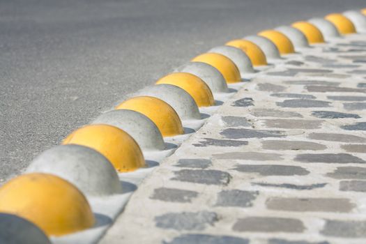 Bent curb close-up separated asphalt road and cobblestone