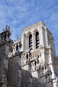 Famous landmark Gothic catholic cathedral Notre-dame on Cite island in Paris France on the blue and cloudy sky background