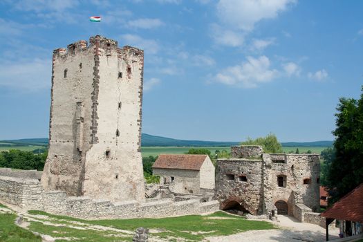 Medieval aged stone Kinizsi castle and tower in Nagyvazsony, Hungary on the blue sky background and countryside surroundings