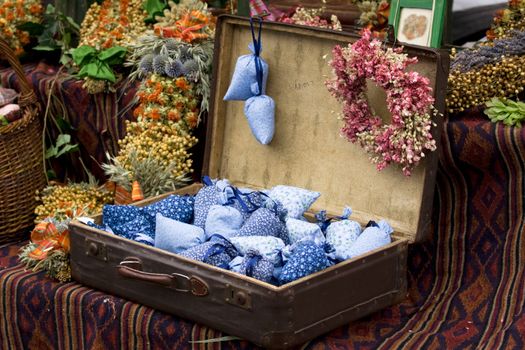 Dried wild flowers and cotton bags with lavender in old fashioned suitcase