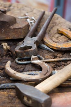 Horseshoes, nippers, hammer and other forging tools close-up