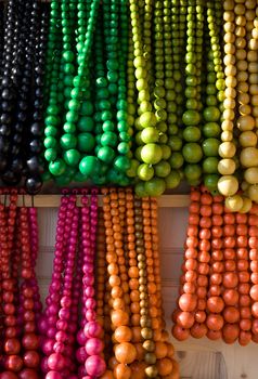 Showcase of handicraft wooden many-colored beads on the craft market close-up