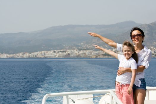 Mother, little child enjoy fresh summer wind and mountain seascape sailing by sea boat