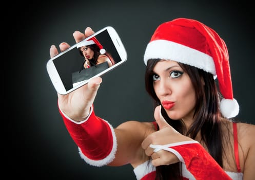 Portrait of beautiful sexy girl wearing santa claus clothes with smartphone