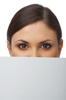 Close up portrait of a young girl hiding behind the blank billboard