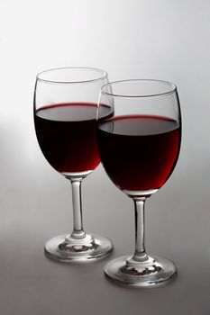 Red wine on white background. Focus is on the first glass