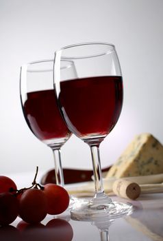 Red wine, grape  and cheese in the background 