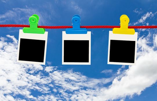 Blank photo frames Hanging by plastic peg on blue sky