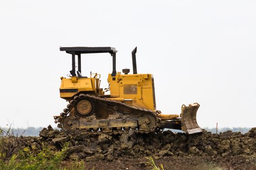 Bulldozer machine doing earth moving work in construction site