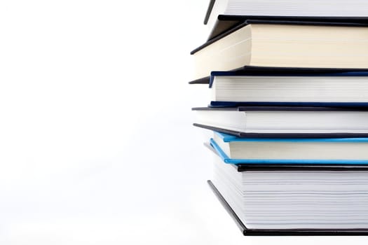 An abstract shot of a pile of books over a white background.