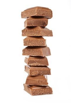 Chunks of Chocolate piled up in front of a white background.